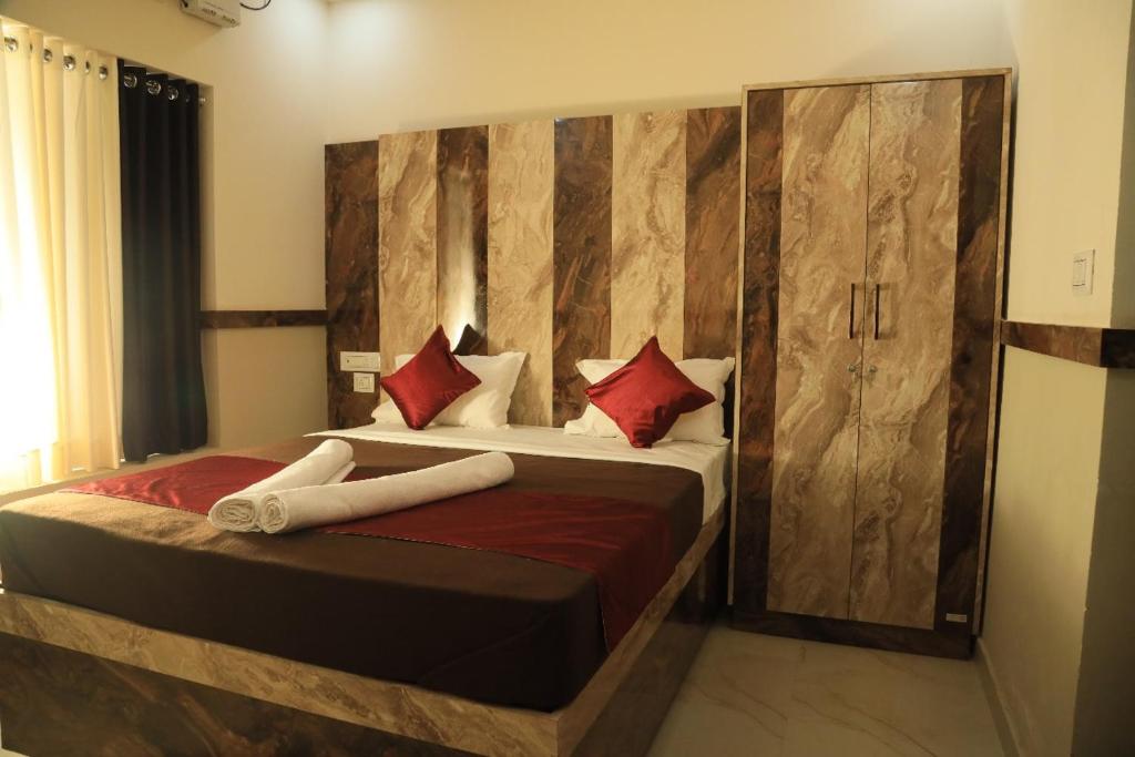 Bekal Eden Resort في Kotikulam: غرفة نوم بها سريرين مع وسائد حمراء
