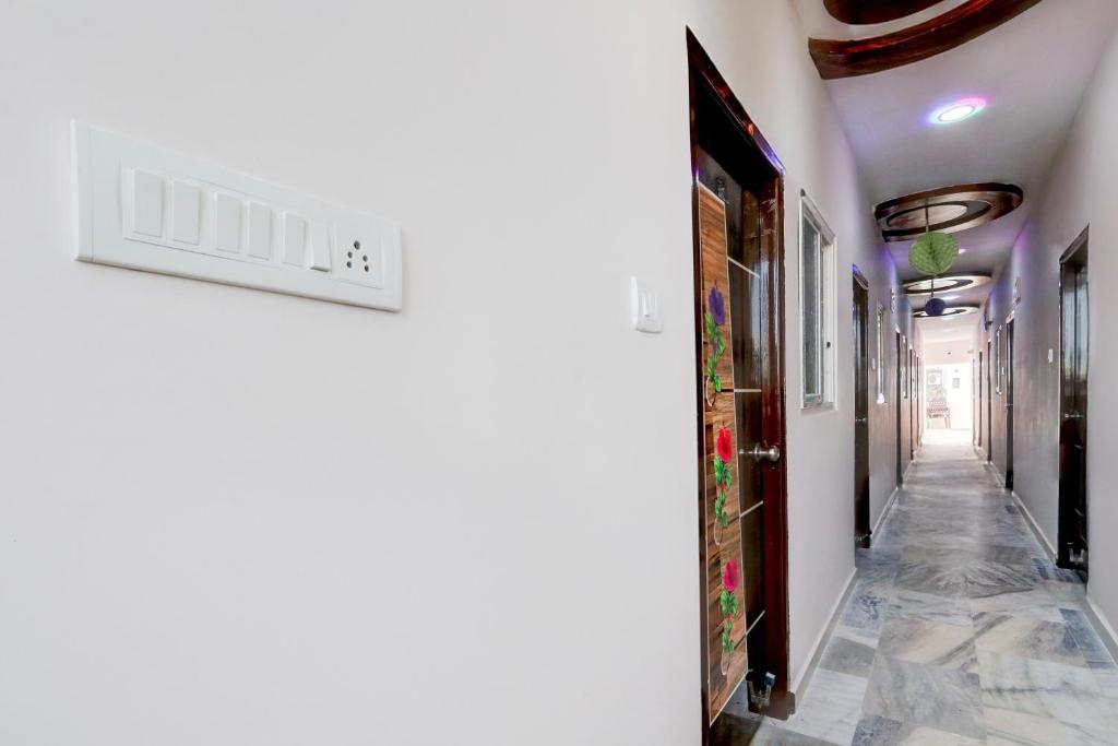 a hallway with white walls and a tile floor at Hotel O Lavish Stay Inn in Hyderabad