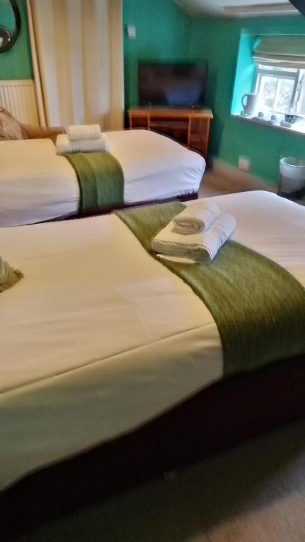 a group of three beds in a room at Kings Head Hotel in Kirkbymoorside