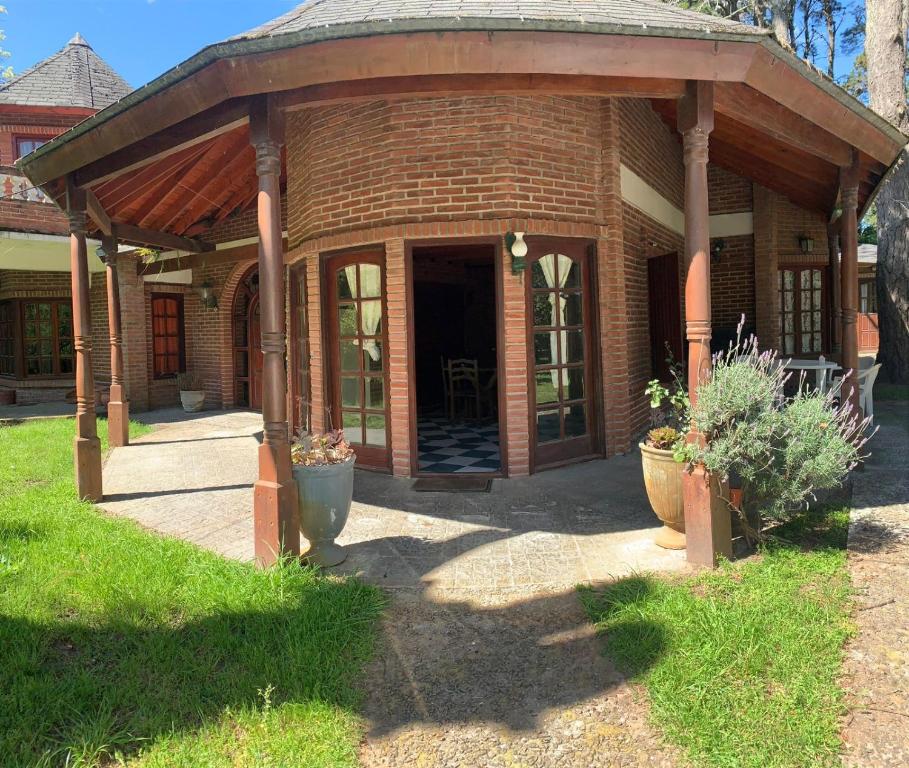 a brick house with a pavilion in the yard at CHALET ENTRE PINOS IDEAL PARA 4 HUESPEDEs in Costa del Este