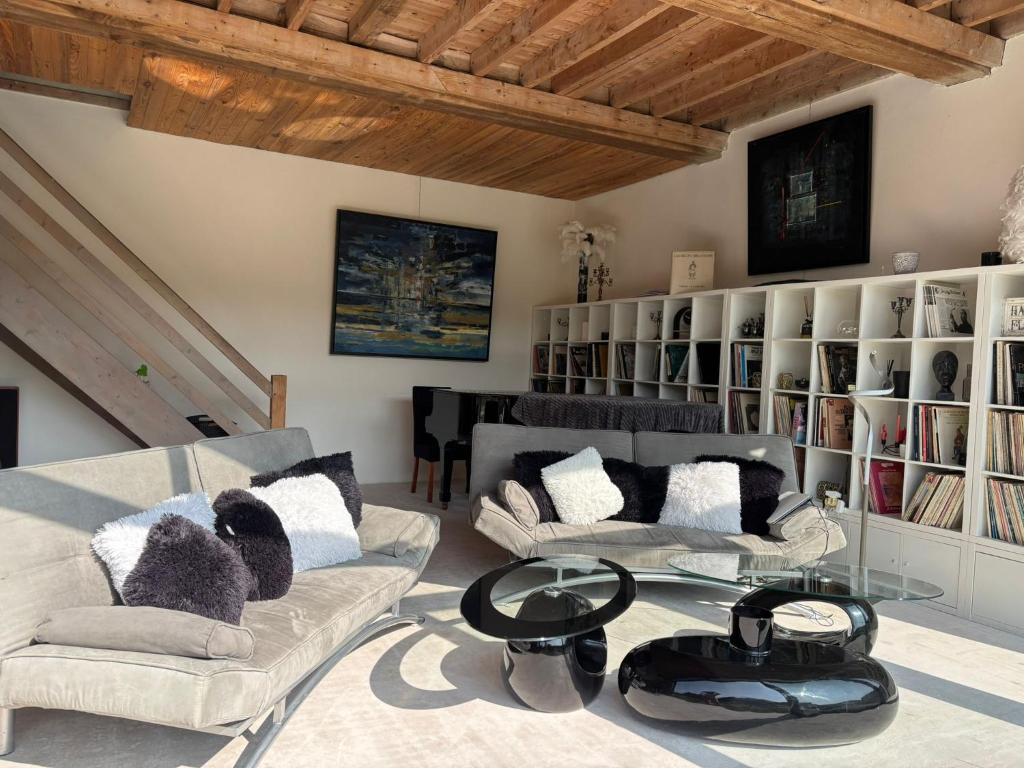 sala de estar con 2 sofás y mesa de cristal en Hameau Fleuri, en Pierrefitte-en-Auge