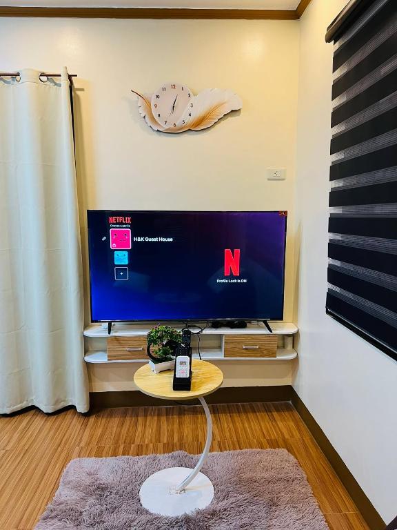 a living room with a tv and a table at H&K Guest House in Urdaneta
