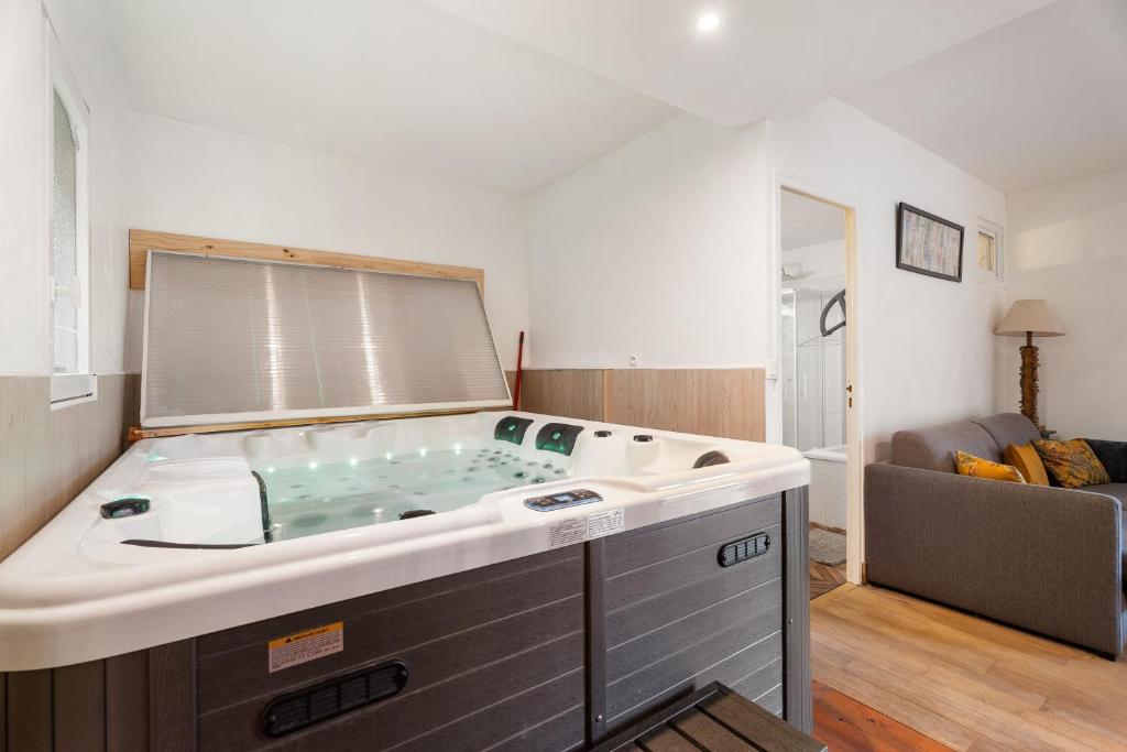 bañera grande en la sala de estar en Gîte du 17 - bien-être avec spa, en Trans
