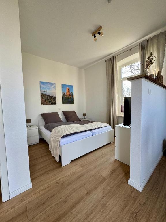 a bedroom with a bed and a television in it at Heuler beim Ochsenturm am Deich in Dingen