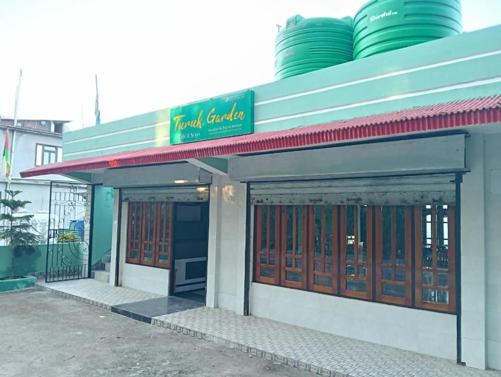 um prédio com uma placa no topo em Turuk Garden Cafe and Stays em Chidām