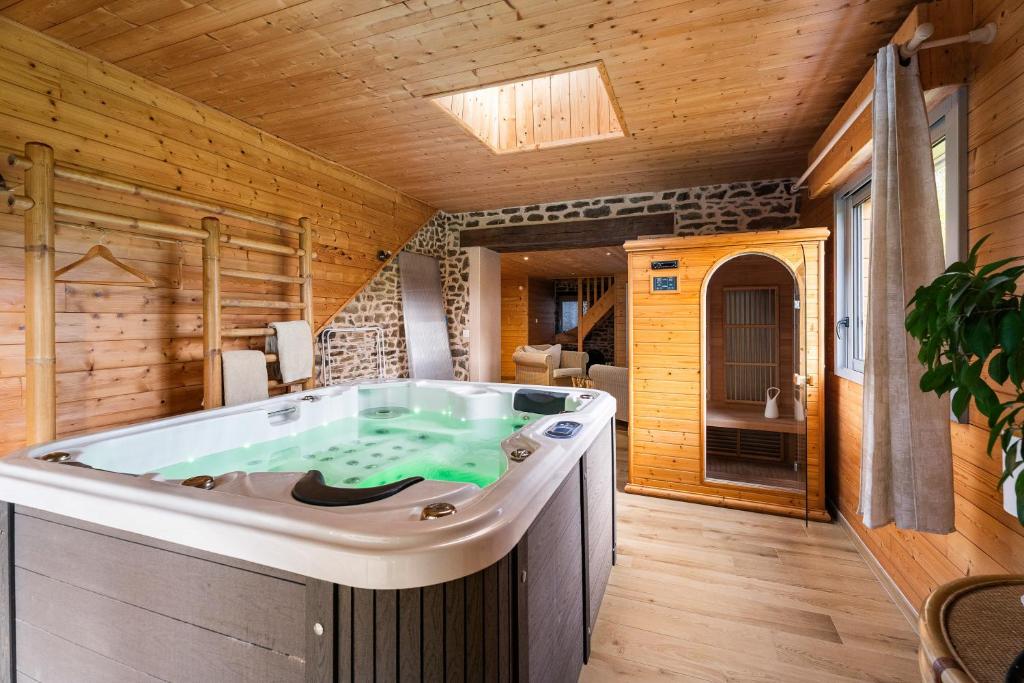 ein Whirlpool in einem Raum mit Holzwänden in der Unterkunft Gîte du 17 - sauna jacuzzi hammam in Trans