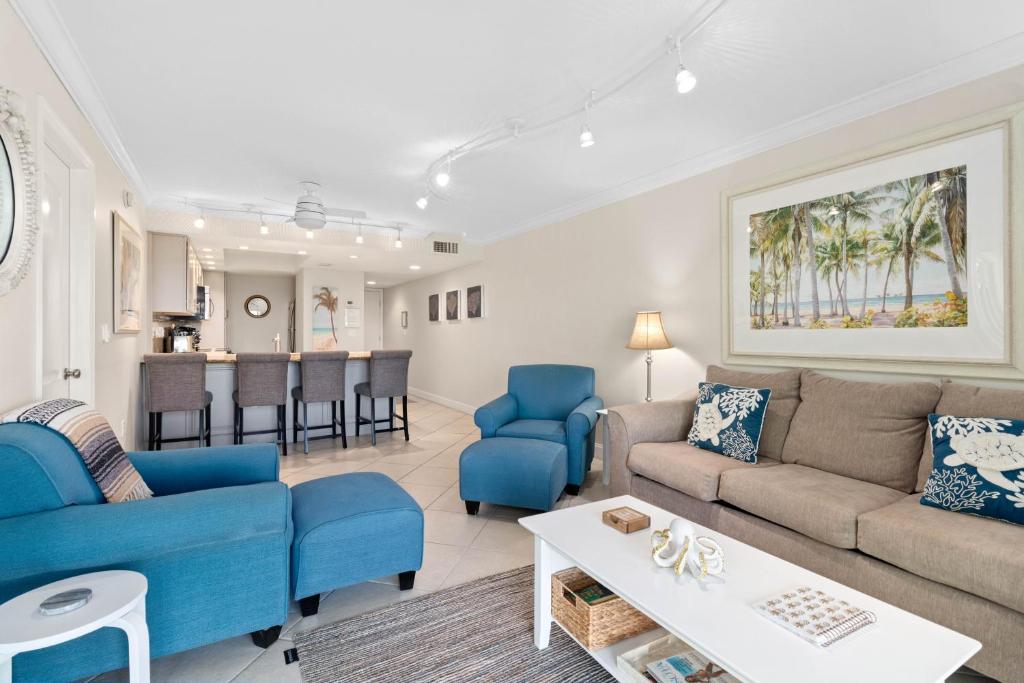 a living room with blue couches and a kitchen at Beach Castle Resort #3 in Longboat Key