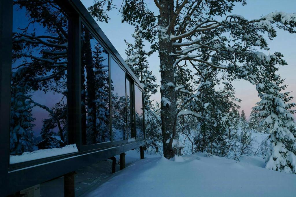 ein Gebäude im Schnee neben einem Baum in der Unterkunft Modern Cabin By The Cross-Country Trails in Svene