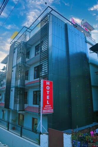 加德满都Hotel Airport Deepshree的前面有红色标志的建筑