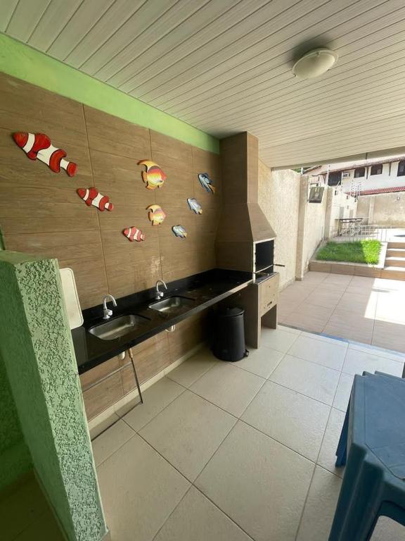 a kitchen with two sinks and fish stickers on the wall at Casa espaçosa e completa para grupos em Salinas in Salinópolis
