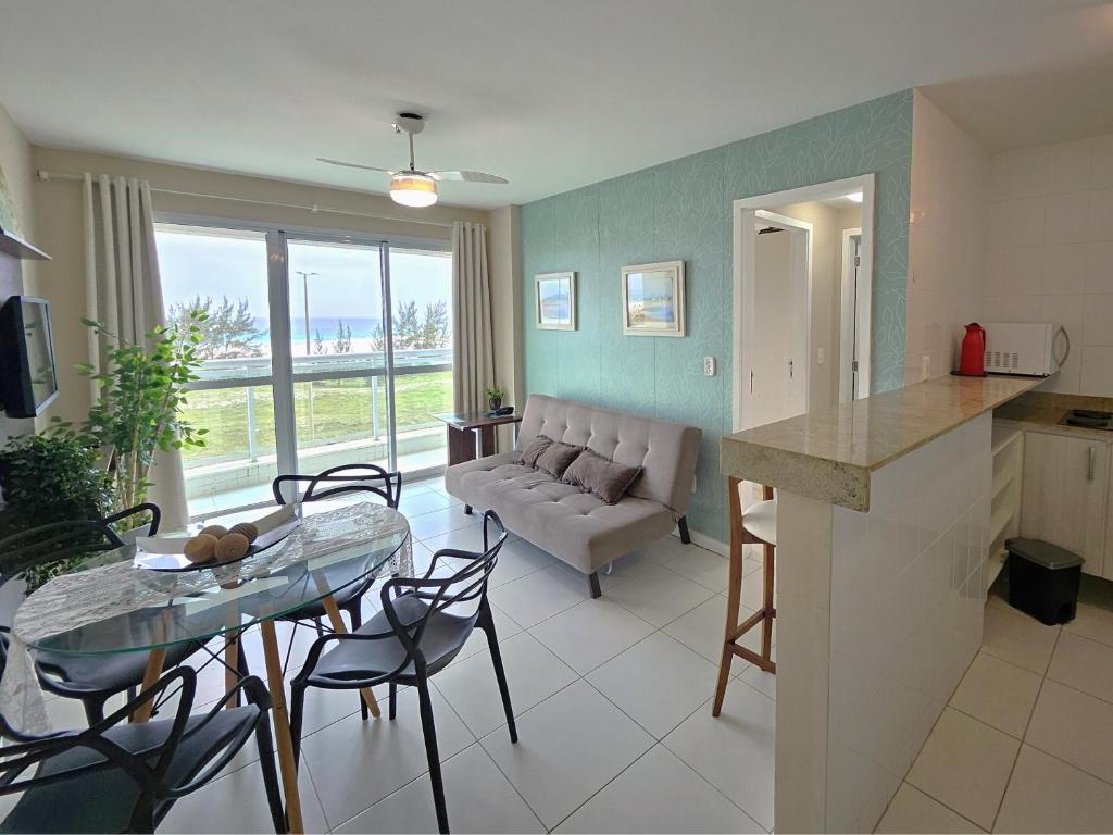 eine Küche und ein Wohnzimmer mit einem Tisch und einer Couch in der Unterkunft PRAIA DO FORTE - PÉ NA AREIA - 6 hóspedes in Cabo Frio