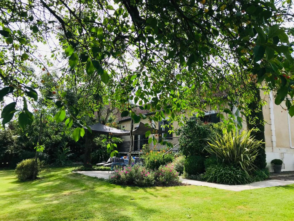 une maison avec une cour dotée de chaises et de plantes dans l'établissement Ferme de Paufy, à Saint-Géry