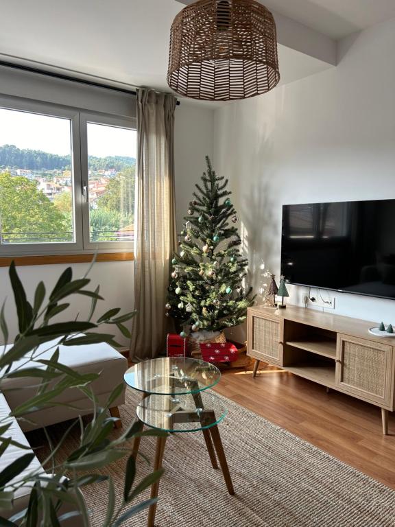 un salon avec un arbre de Noël et une télévision dans l'établissement Apartamento Enseñanza - Barco a Vigo Gratis - Kid Friendly, à Cangas