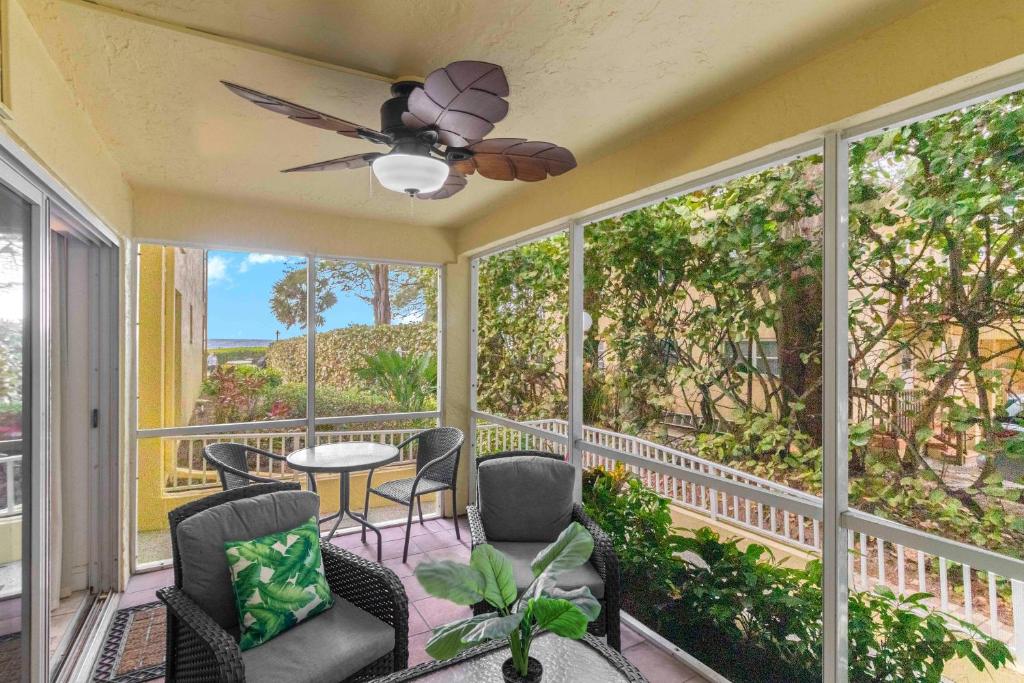 una veranda schermata con ventilatore a soffitto, tavolo e sedie di Beach Castle Resort #9 a Longboat Key