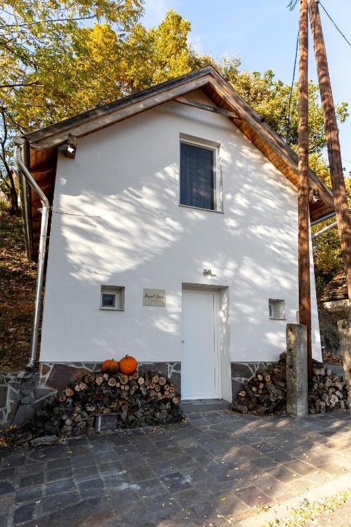 a white house with a white door and pumpkins at Royal Cave Noszvaj in Noszvaj