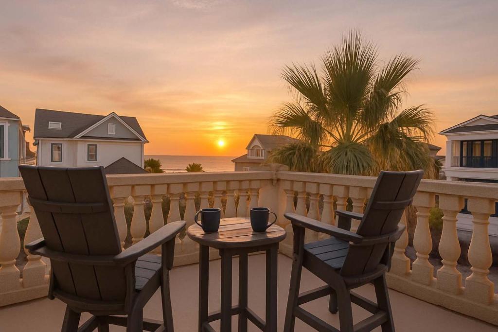 Duas cadeiras e uma mesa numa varanda com um pôr-do-sol em Luxury 7BR w Ocean Views & Private Pool em Hilton Head Island