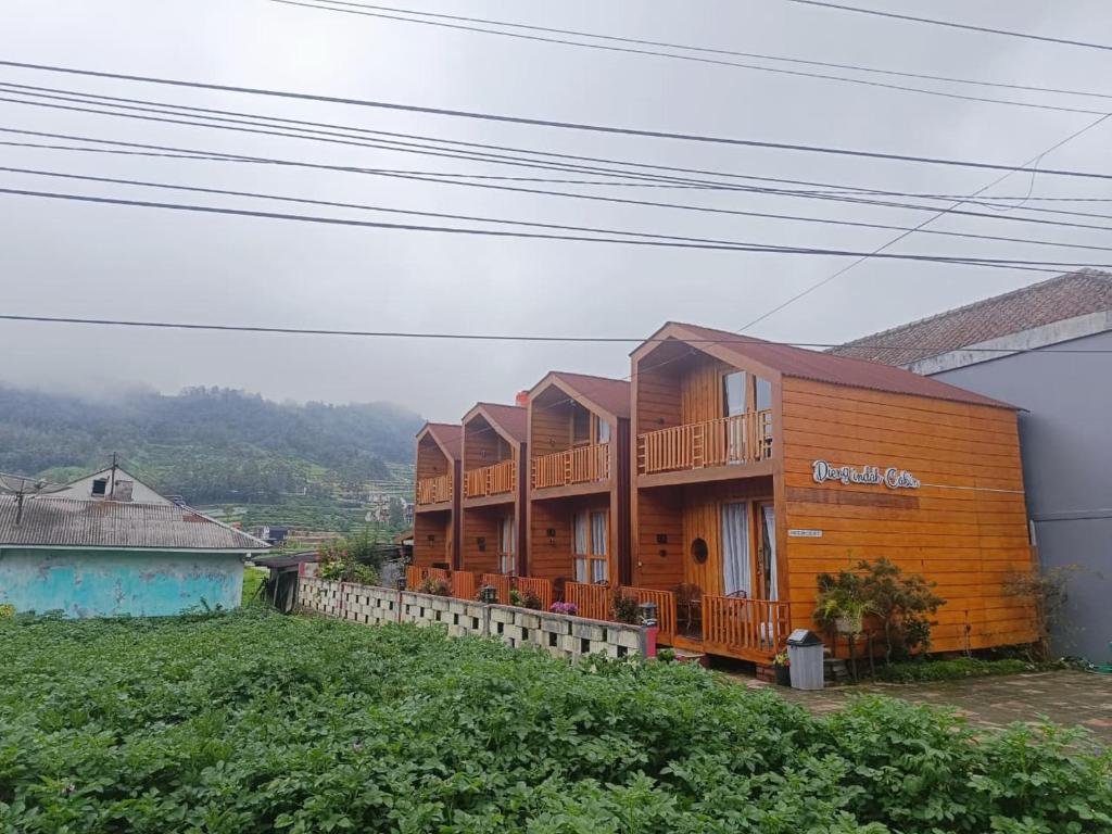 a row of wooden houses on top of a hill at Dieng Indah Villa & Cabin by Hello Room in Dieng