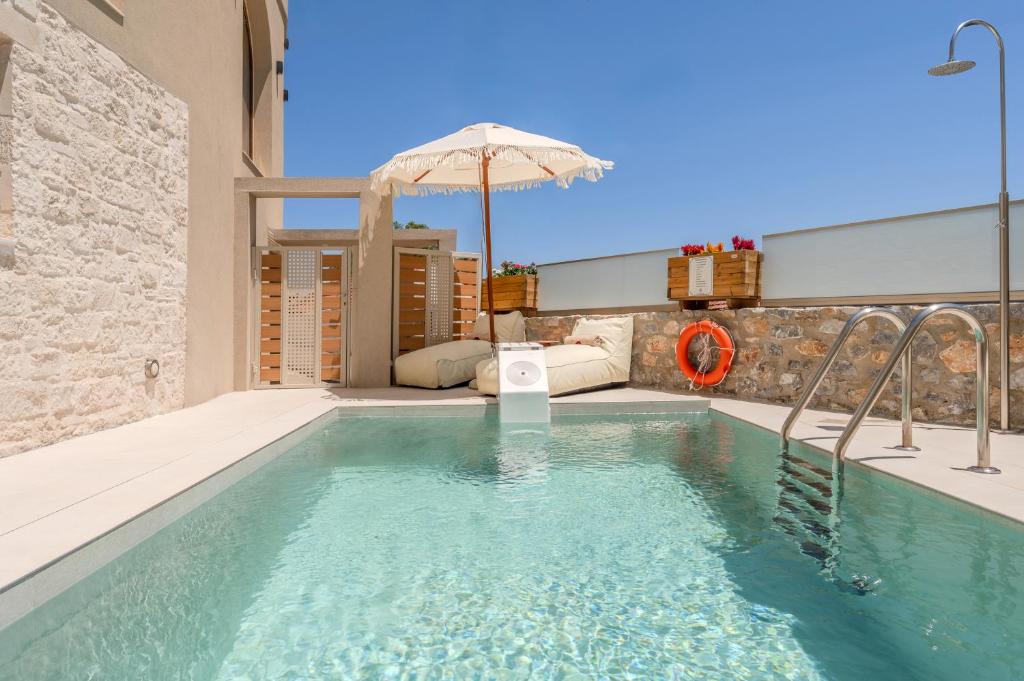 ein Swimmingpool mit Sonnenschirm in einem Haus in der Unterkunft Casa Karinea - Serene Stone House Retreat in Áyios Vasílios