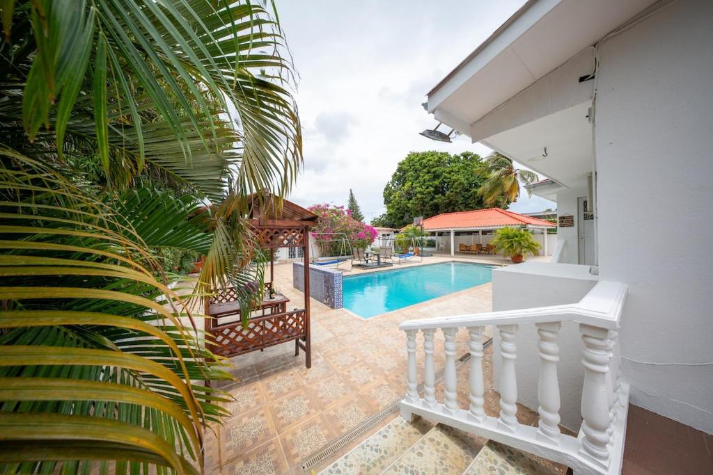 een huis met een zwembad en een witte trap bij Villa Laura, Central Spacious Oasis with Private Pool in Willemstad
