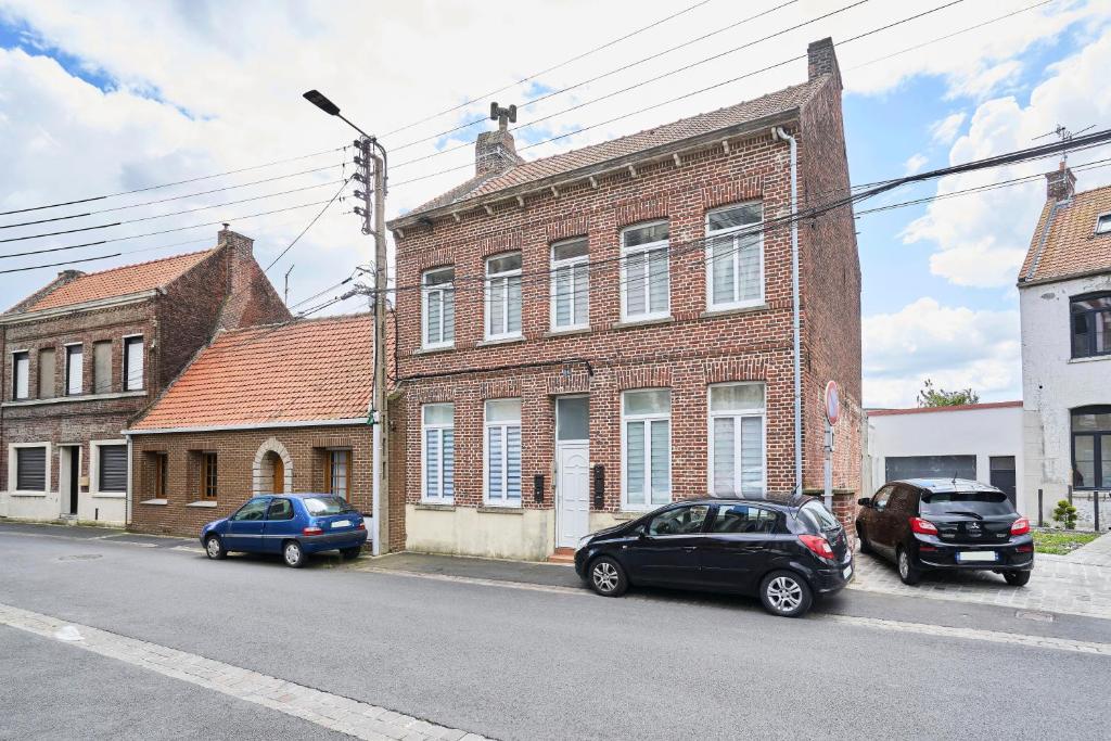 deux voitures garées devant un bâtiment en briques dans l'établissement Le Duo - Les Demeures d'Adrien, à Carvin
