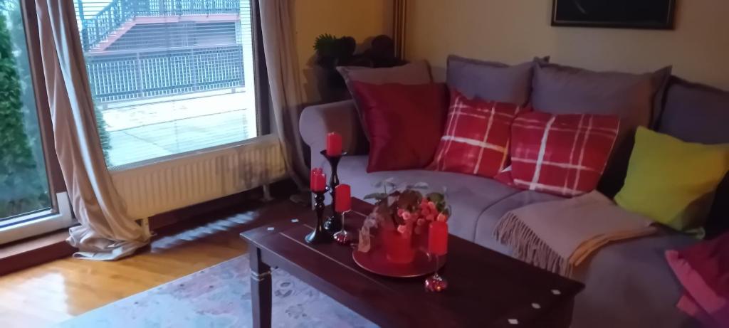 a living room with a couch with red and yellow pillows at Apartment Baci for 4 guests in Ljubljana