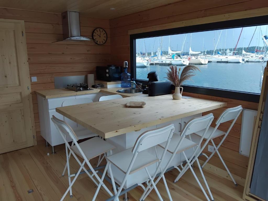 une cuisine avec une table et des chaises ainsi qu'une grande fenêtre dans l'établissement Bateau Lac du Der - Sainte-Marie - Navigation, 