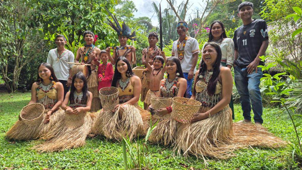 un gruppo di persone che posano per una foto sull'erba di Lisan Wasi a Indillana