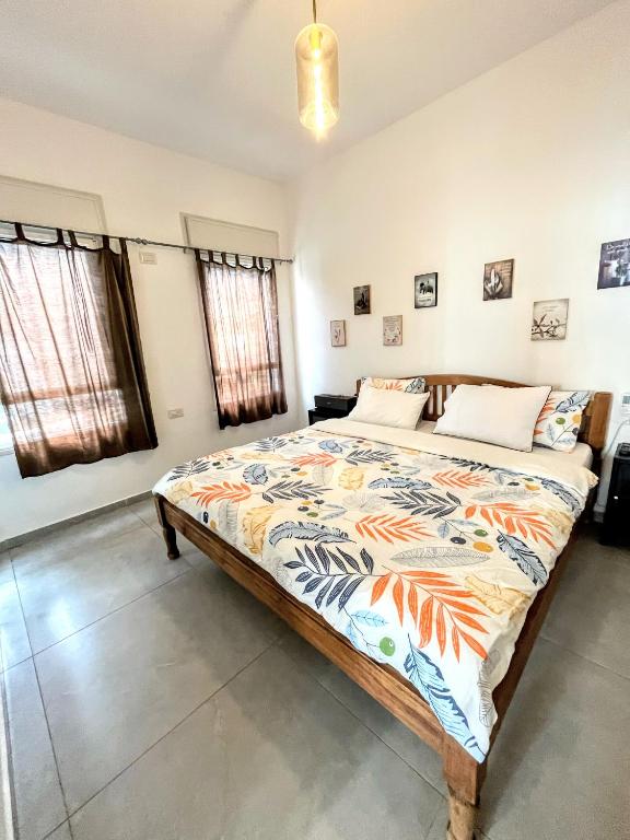 a bedroom with a large bed with a colorful comforter at Up the Hill in Tiberias