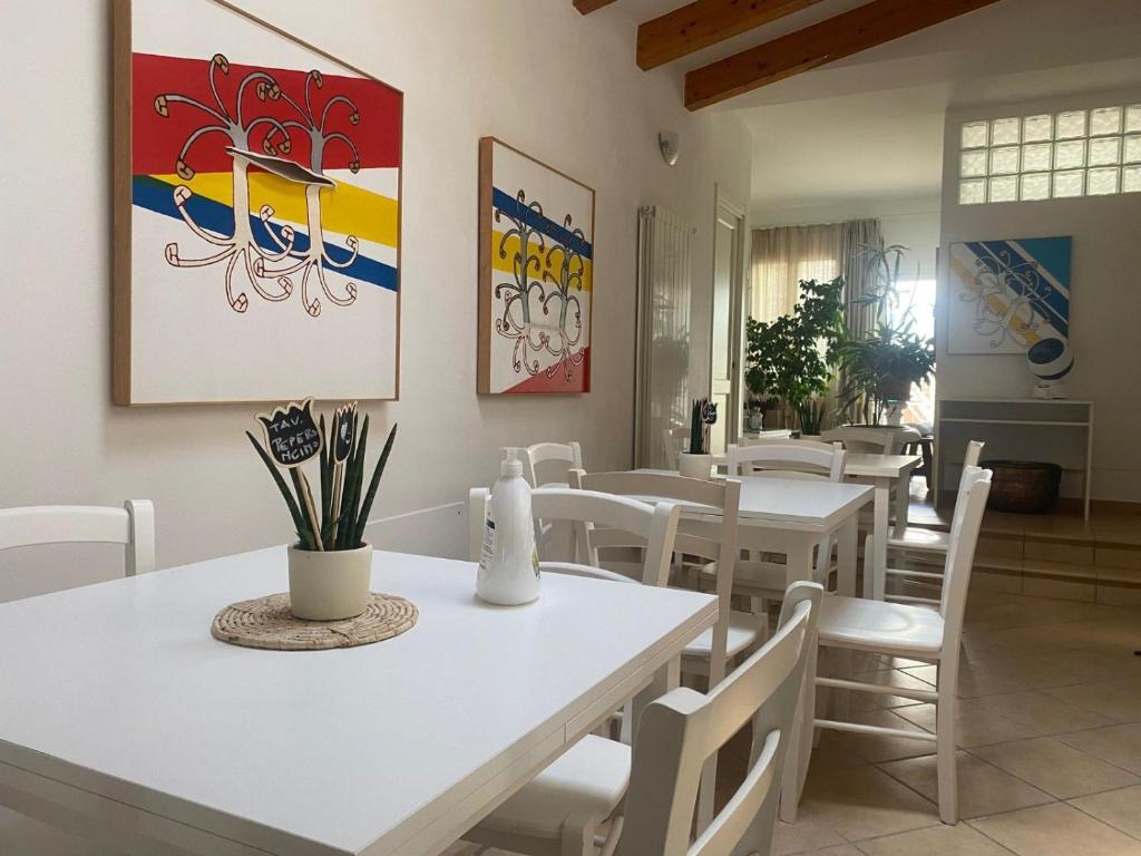 a dining room with white tables and white chairs at Rosa Di Mare Guest House in Borgio Verezzi