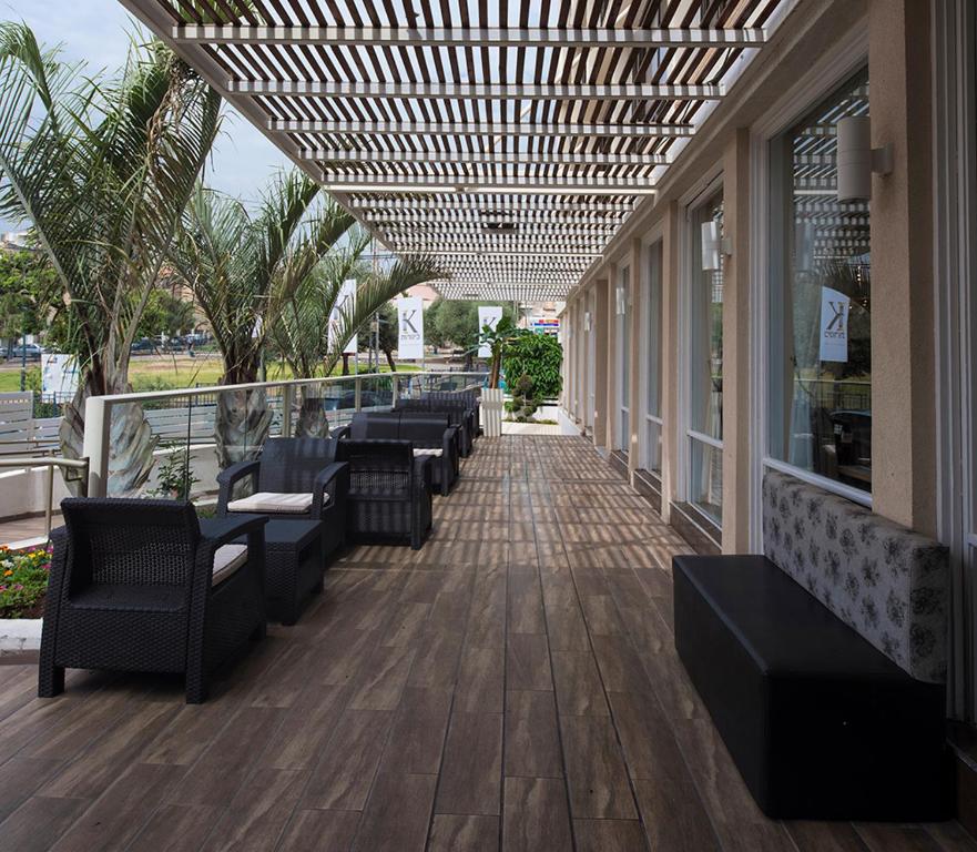 una fila de sillas y mesas en un porche en Kinorot Hotel, en Tiberíades