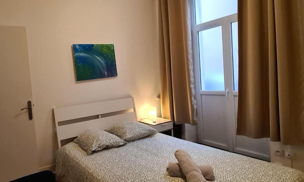 维希L'Absolu 1, Spacieux, rez-de-chaussée, Sécurisé的一间卧室配有一张带窗户的床和床罩