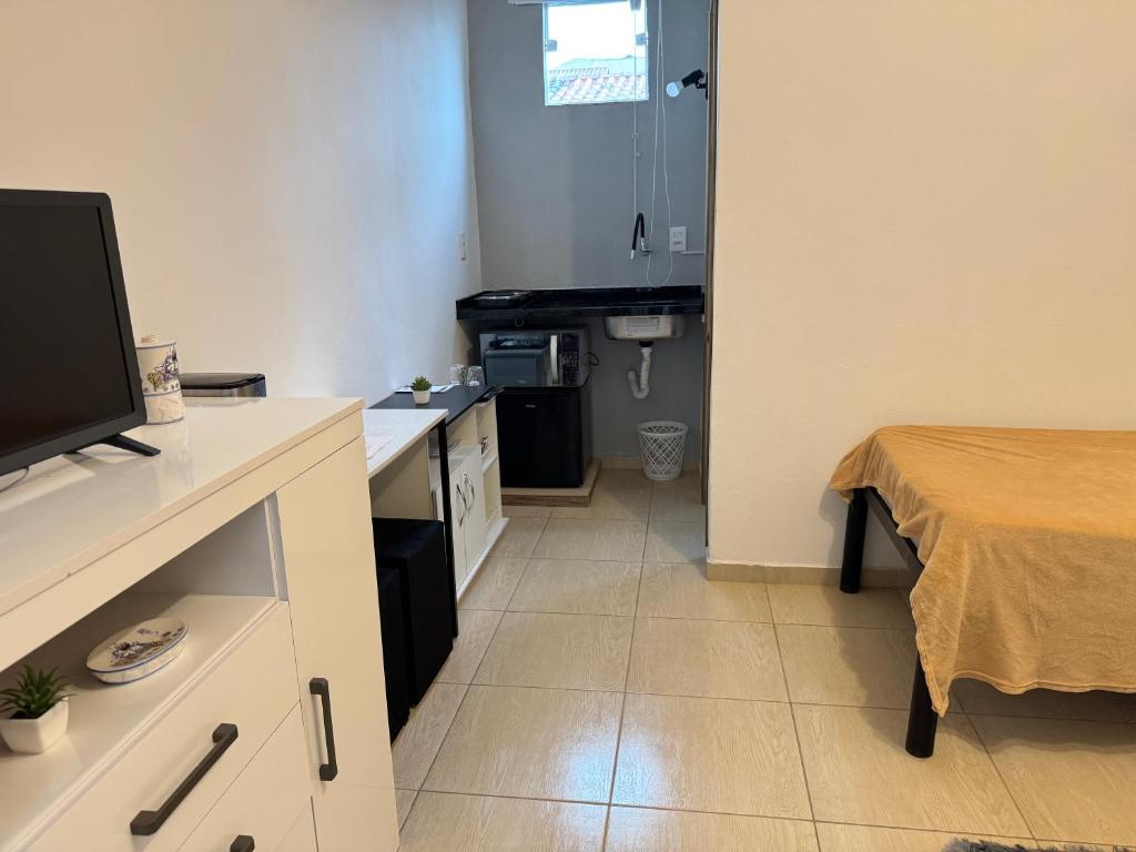 una camera con cucina, letto e televisore di Suíte Park e Mar quarto 2 a Penha