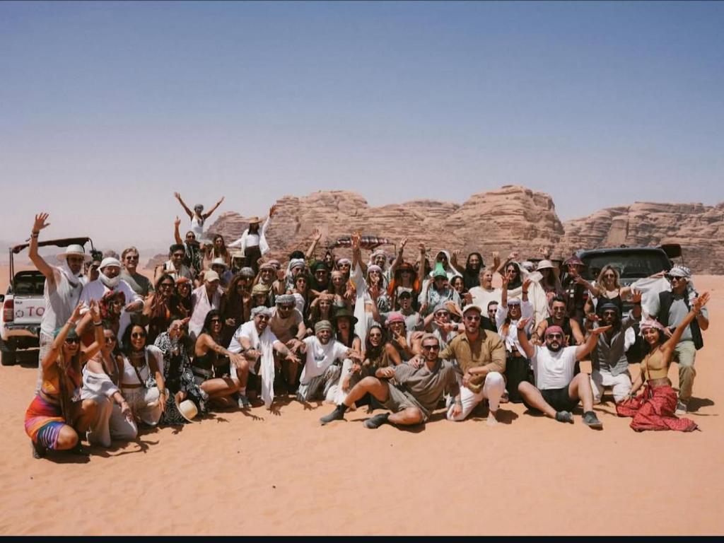 a group of people posing for a picture in the desert at Royal camp in Wadi Rum