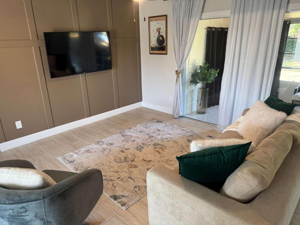 Cape Coral Beach House في كيب كورال: غرفة معيشة مع أريكة وتلفزيون بشاشة مسطحة