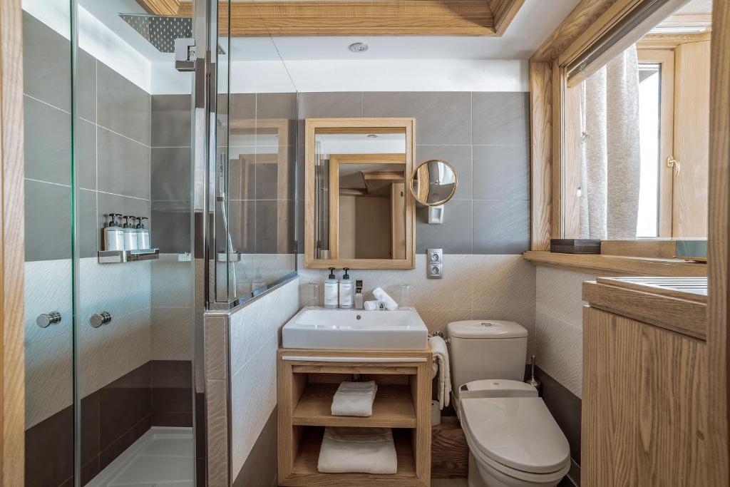 ein Badezimmer mit Waschbecken, Toilette und Dusche in der Unterkunft Hotel Annapurna in Courchevel
