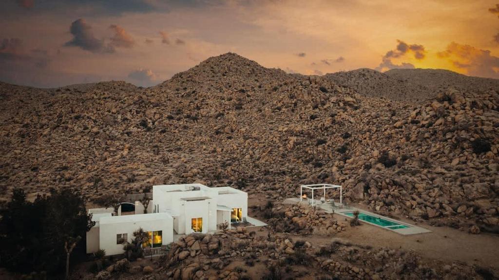 a group of buildings in a rocky mountain at Bolder House By The Cohost Company in Joshua Tree