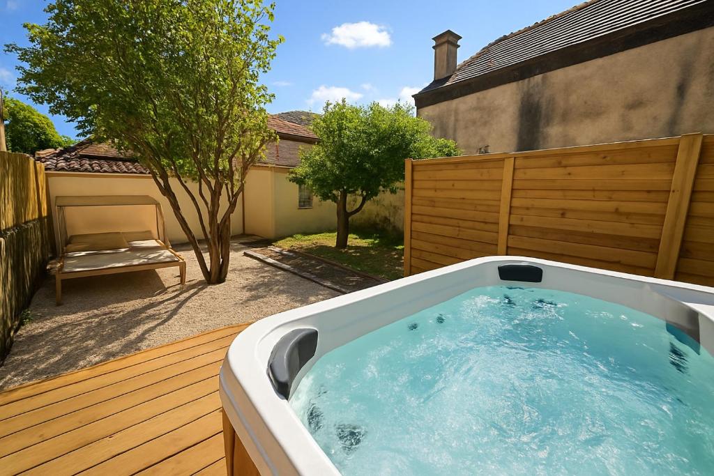 bañera de hidromasaje en la terraza de un patio trasero en L'Antre du Pin, en Lourdes
