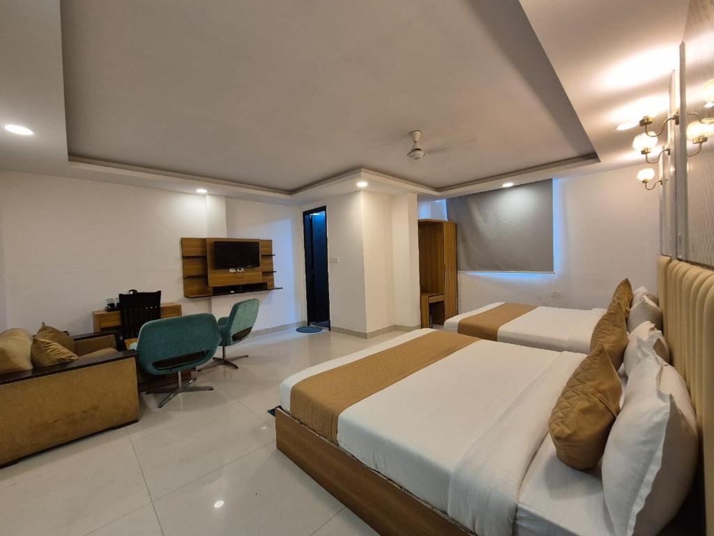 Una habitación de hotel con una cama grande y un televisor. en Precesion Palace Suites Near Delhi Airport, en Nueva Delhi