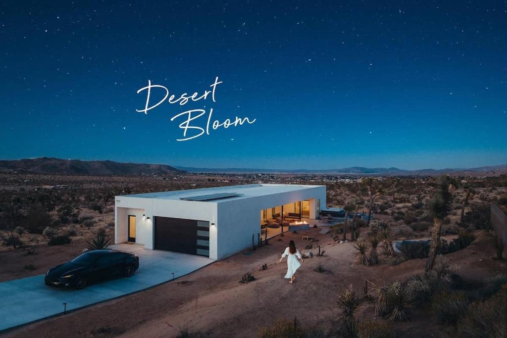 een vrouw die voor een wit huis in de woestijn loopt bij Desert Bloom By The Cohost Company in Joshua Tree