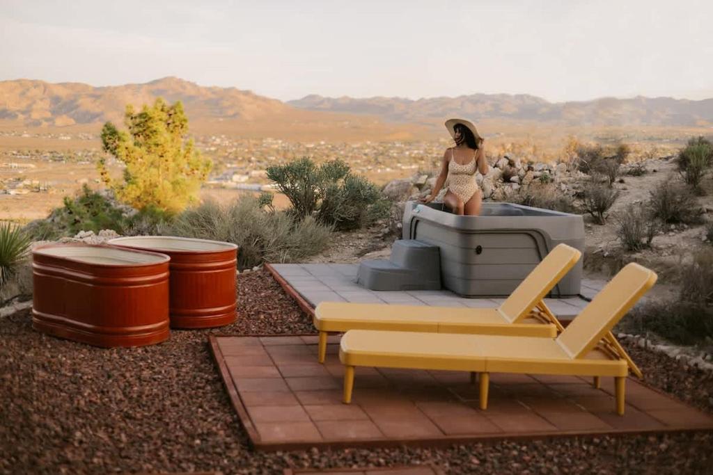a woman in a bikini sitting on a jeep in the desert at Mandarin Escape By The Cohost Company in Yucca Valley