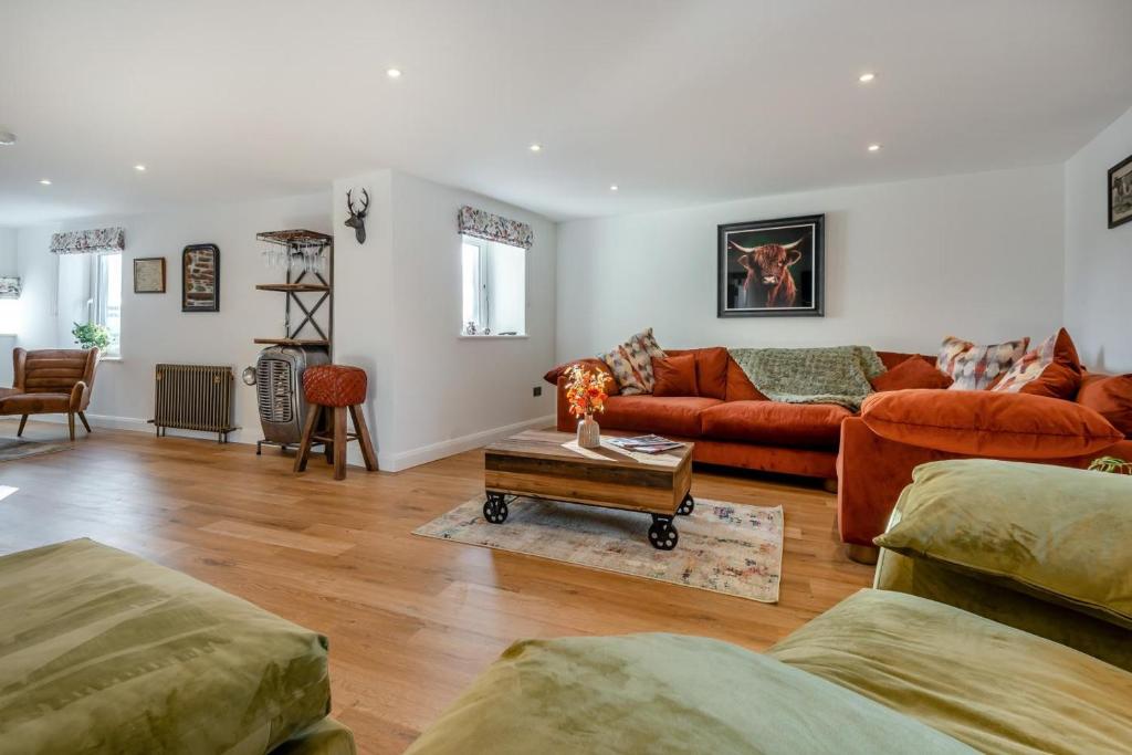 ein Wohnzimmer mit orangefarbenen Sofas und einem Tisch in der Unterkunft 3 Bed in Wigton oc-f33746 in Wigton