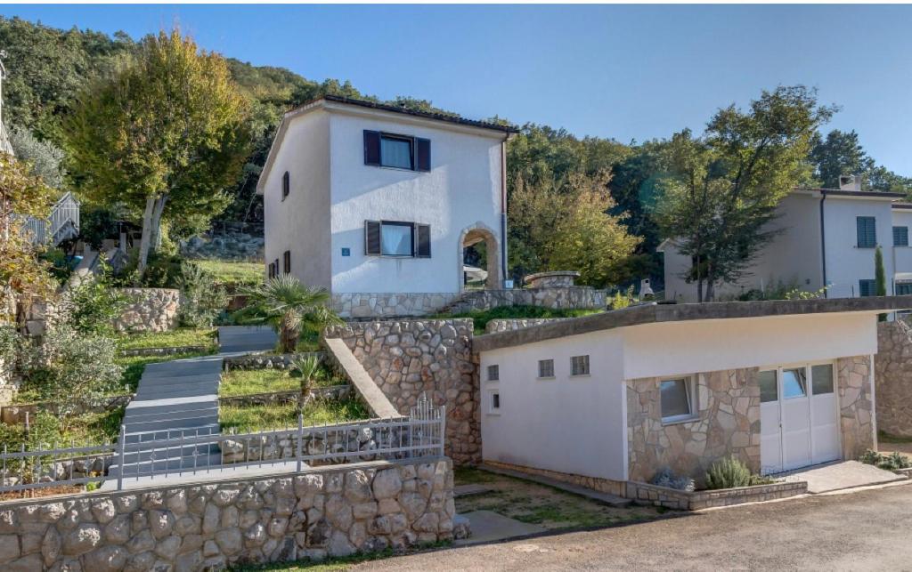 an image of a house with a stone wall at Adrialana in Porozina