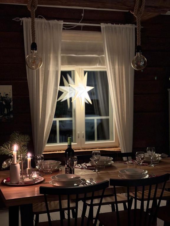 a dining room table with a star in a window at Villa Hirsipirtti in Rovaniemi