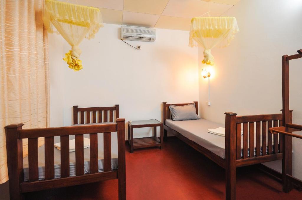 a room with two cribs and a bed in a room at Green Villa in Kahawa