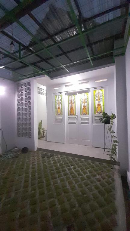 a room with white doors and stained glass windows at Omah Saha at Kraton in Yogyakarta