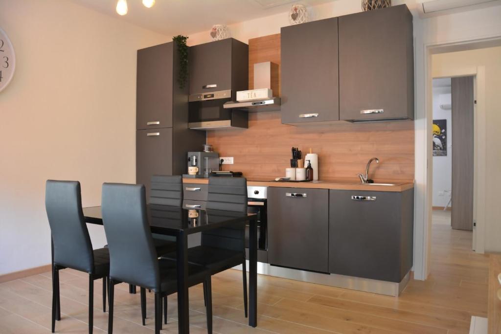 Una cocina con una mesa de comedor y sillas negras. en Ca' Serenella, en Venecia