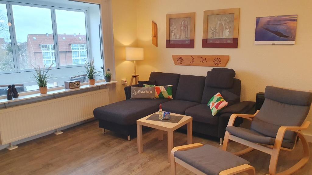 un salon avec un canapé, des chaises et une table dans l'établissement Küstenoase, à Cuxhaven