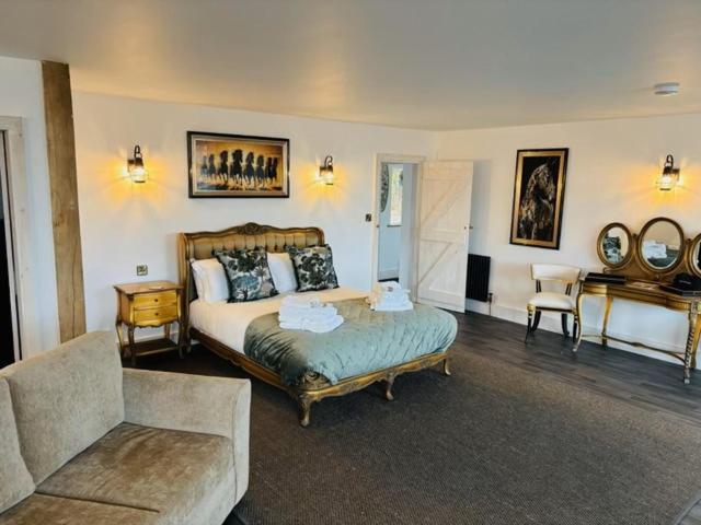 a bedroom with a bed and a couch and a piano at St Oswalds Estate Lodges in Whitby
