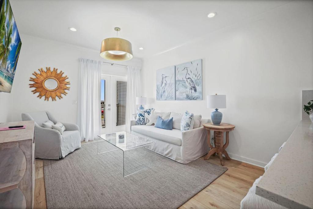 a white living room with a couch and a table at Quiet Harbor Condo-Private Balcony-Relaxing Stay in Pass Christian
