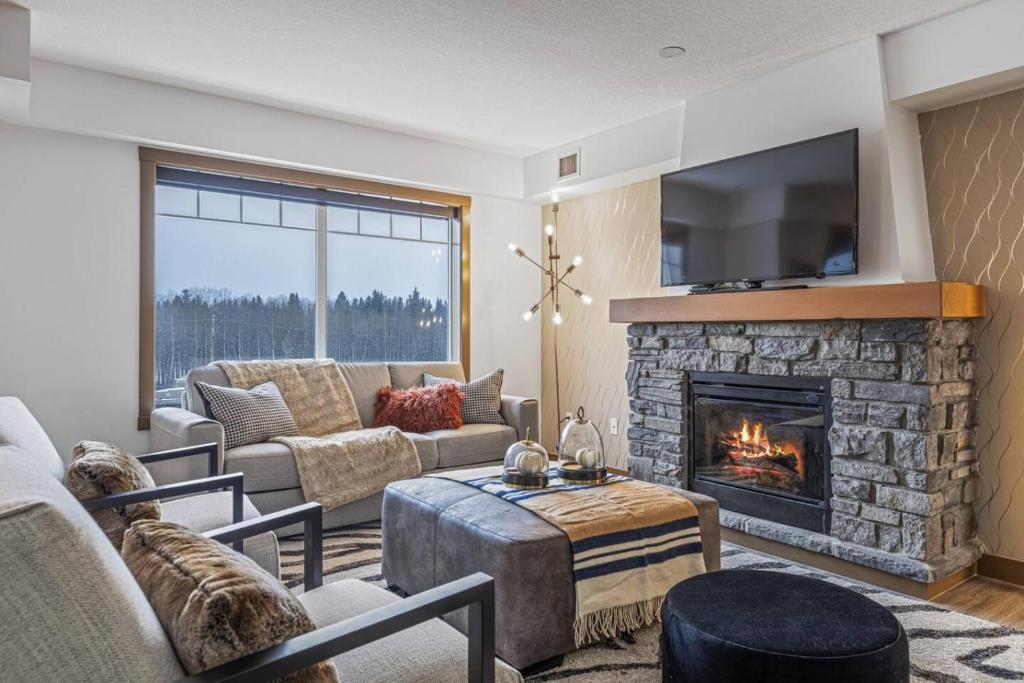 a living room with a fireplace and a tv at Free Arcade Delightful Stay in Rocky Mountains in Dead Man's Flats